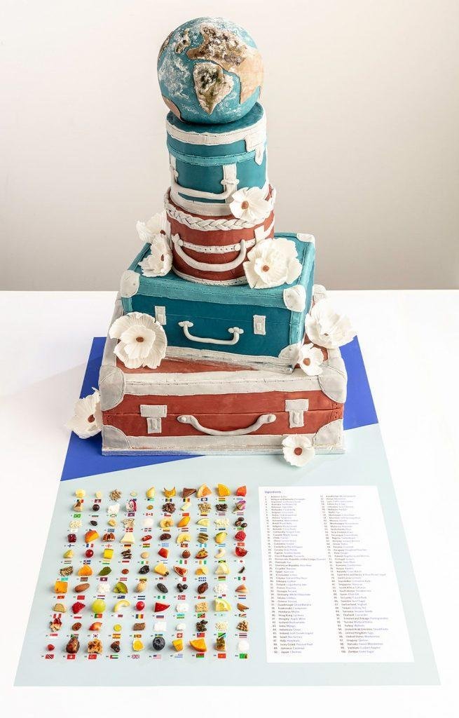 The five tier cake, decorated to look like suitcases with the top layer designed to look like the Earth