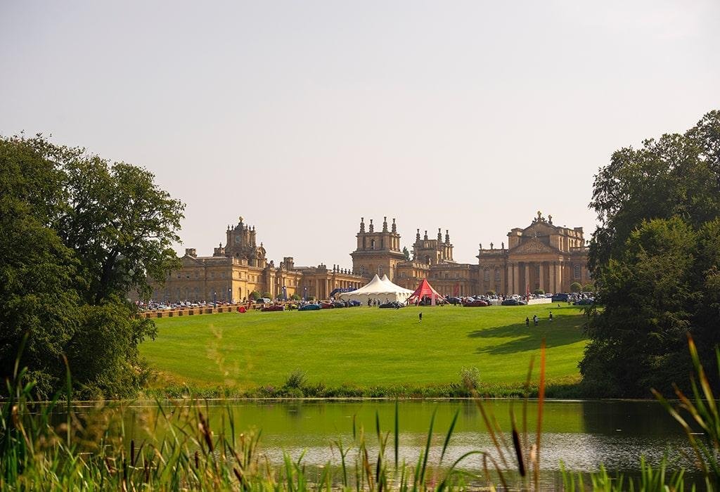 A wide shot view of the palace framed by trees and a lake